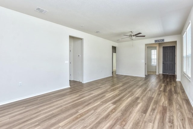 716 Kitty Hawk Rd, Georgetown, TX 78633 - unfurnished living room featuring wood finished floors, ceiling fan, and baseboards