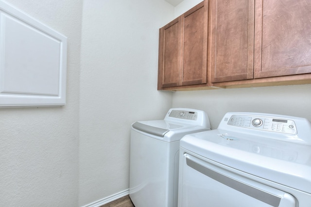 washroom featuring washing machine and dryer and cabinets