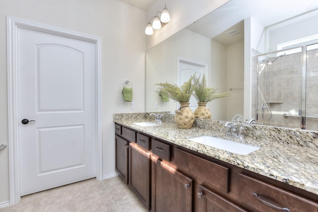 bathroom featuring a shower with door, tile patterned floors, and vanity