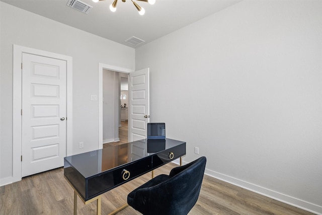 office featuring an inviting chandelier and hardwood / wood-style flooring