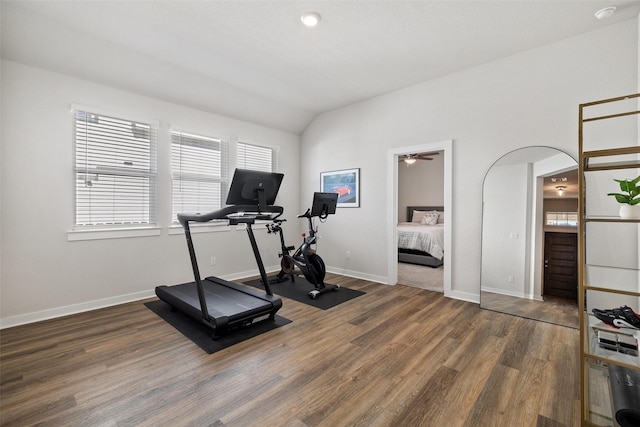 workout area with ceiling fan, dark hardwood / wood-style floors, and lofted ceiling