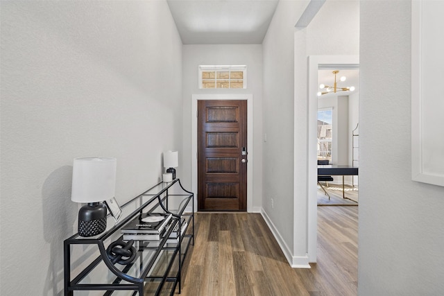 entrance foyer with a high ceiling, an inviting chandelier, and hardwood / wood-style floors