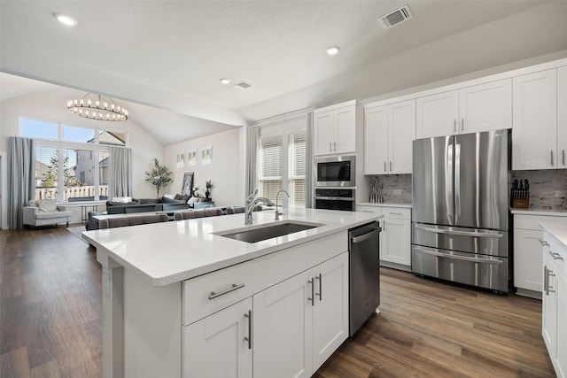 kitchen with white cabinetry, appliances with stainless steel finishes, lofted ceiling, and tasteful backsplash