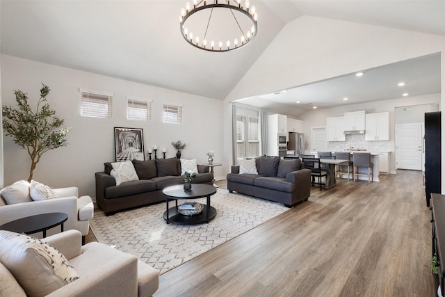 living room with light wood-type flooring, plenty of natural light, and a chandelier