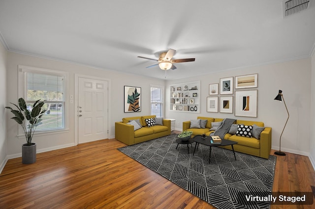 living room featuring ornamental molding, ceiling fan, dark hardwood / wood-style flooring, and built in shelves