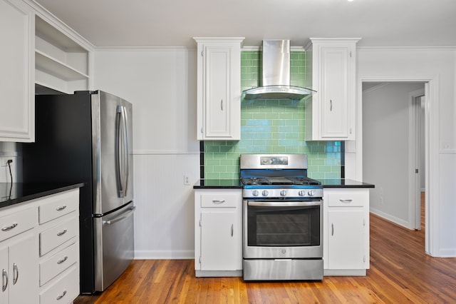 kitchen featuring appliances with stainless steel finishes, wall chimney exhaust hood, light wood-type flooring, and white cabinets