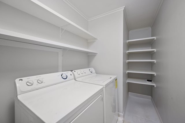 laundry room with light tile patterned floors, ornamental molding, and washing machine and dryer