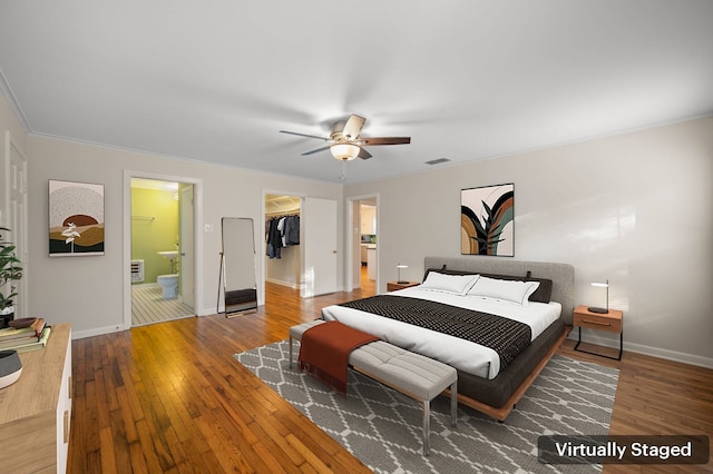 bedroom with a walk in closet, wood-type flooring, a closet, and ensuite bathroom