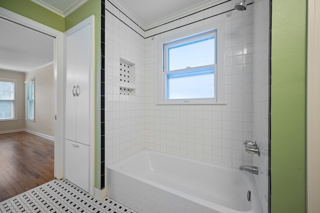 bathroom with crown molding, tiled shower / bath combo, and tile patterned flooring