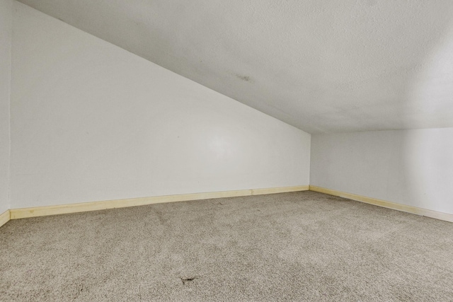 bonus room featuring carpet, a textured ceiling, and vaulted ceiling