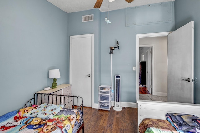 bedroom featuring ceiling fan, a textured ceiling, and dark hardwood / wood-style flooring