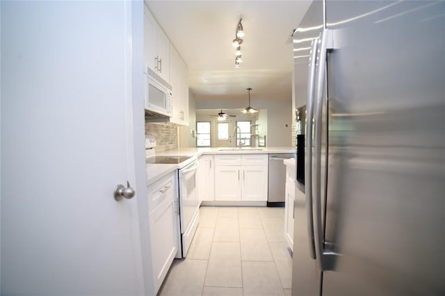 kitchen featuring tasteful backsplash, sink, hanging light fixtures, appliances with stainless steel finishes, and white cabinets