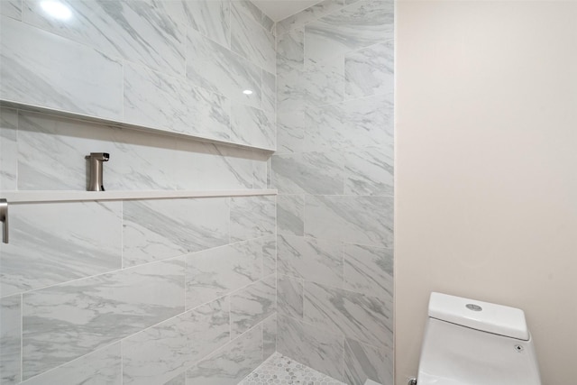 bathroom with toilet and a tile shower