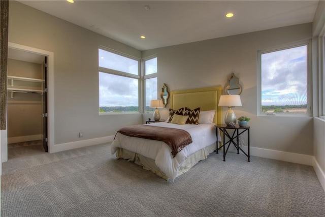 carpeted bedroom with a walk in closet