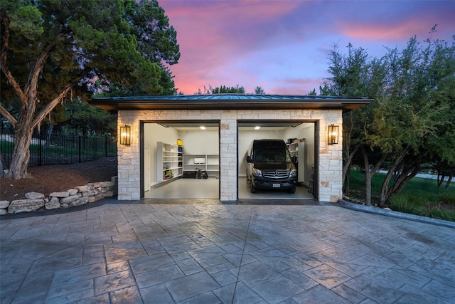 view of garage at dusk