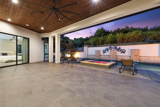 patio terrace at dusk with a hot tub and ceiling fan