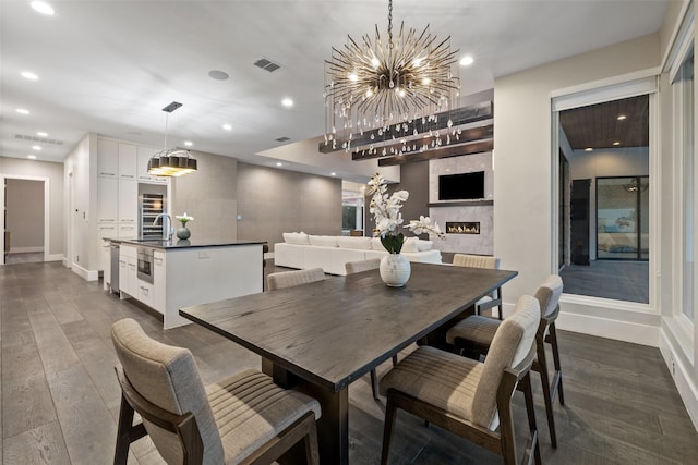 dining room with sink, a chandelier, and dark hardwood / wood-style flooring