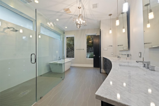 bathroom featuring vanity, an inviting chandelier, and independent shower and bath