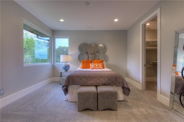 carpeted bedroom with a walk in closet