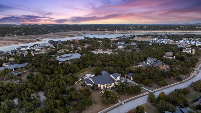 aerial view at dusk featuring a water view