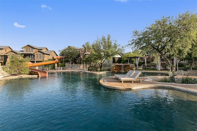 view of pool with a water view, a pergola, and a water slide