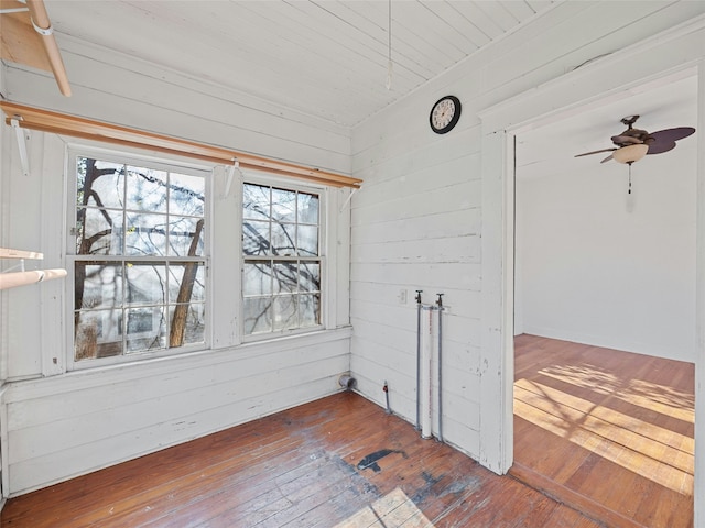 spare room featuring wood walls, ceiling fan, and hardwood / wood-style floors