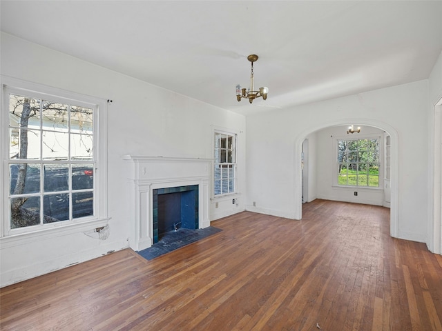 unfurnished living room featuring hardwood / wood-style floors and a notable chandelier