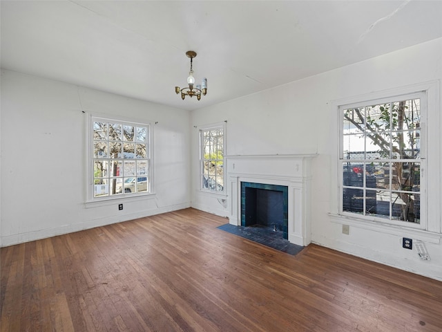 unfurnished living room with wood-type flooring and a chandelier