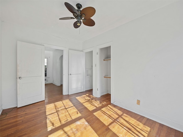 unfurnished bedroom featuring ceiling fan, connected bathroom, and hardwood / wood-style floors