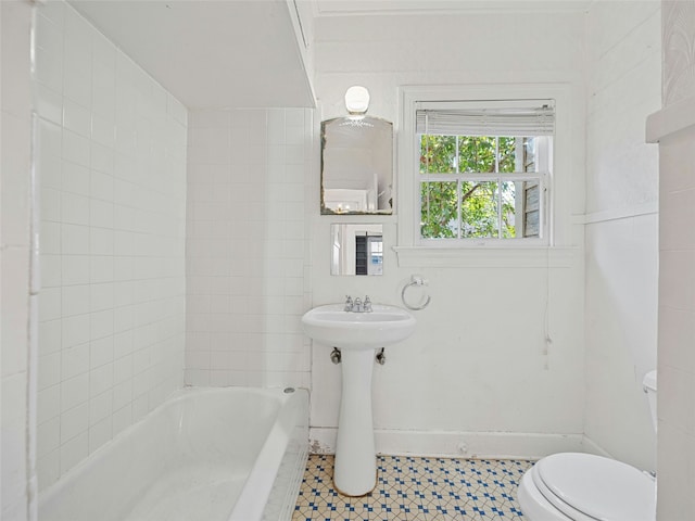 bathroom featuring toilet, a tub, and sink