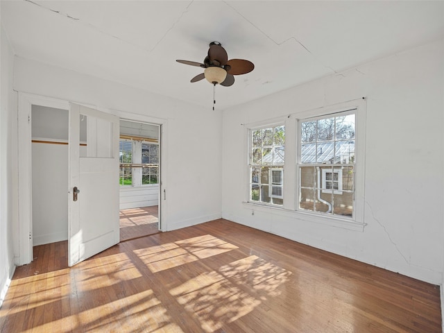 spare room with ceiling fan, hardwood / wood-style flooring, and a healthy amount of sunlight