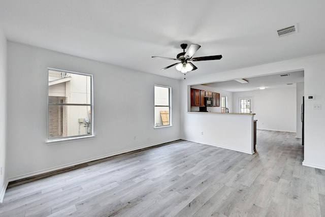 unfurnished living room featuring ceiling fan and light wood-type flooring