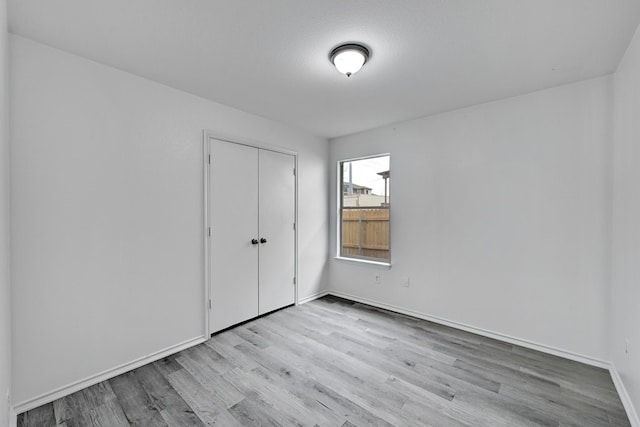 unfurnished bedroom with a closet and light hardwood / wood-style floors