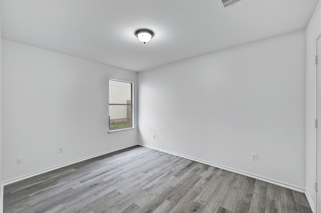 unfurnished room featuring hardwood / wood-style floors and a textured ceiling