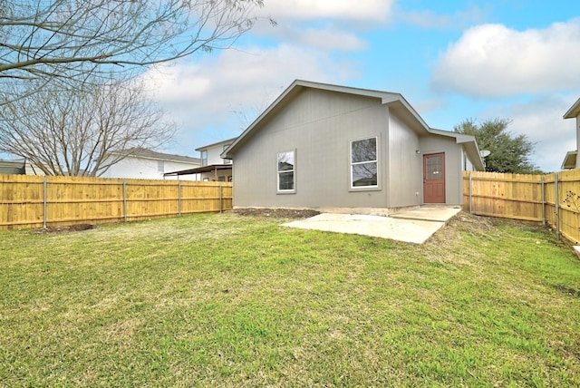 back of house with a lawn and a patio