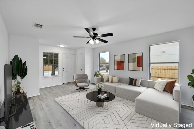 living room with ceiling fan and light hardwood / wood-style flooring