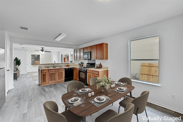 dining room with ceiling fan, sink, and light hardwood / wood-style floors