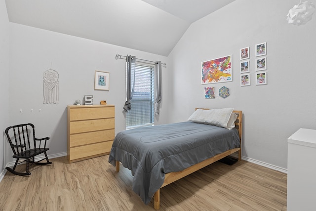 bedroom with lofted ceiling and light wood-type flooring