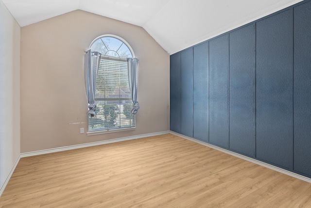 unfurnished room with lofted ceiling and wood-type flooring