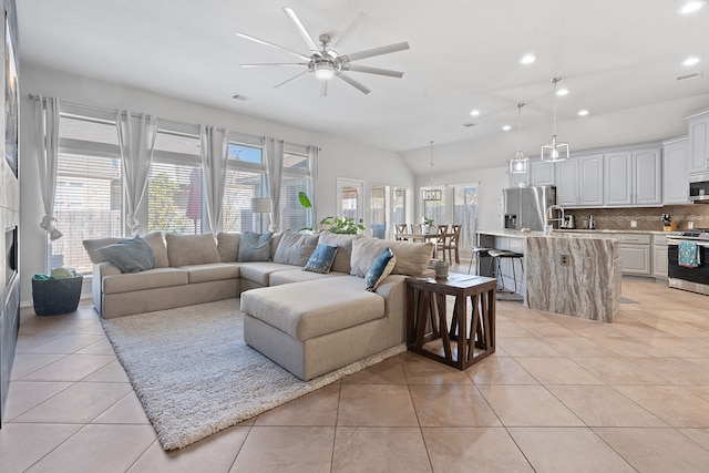 living room featuring vaulted ceiling, ceiling fan, light tile patterned flooring, and a healthy amount of sunlight