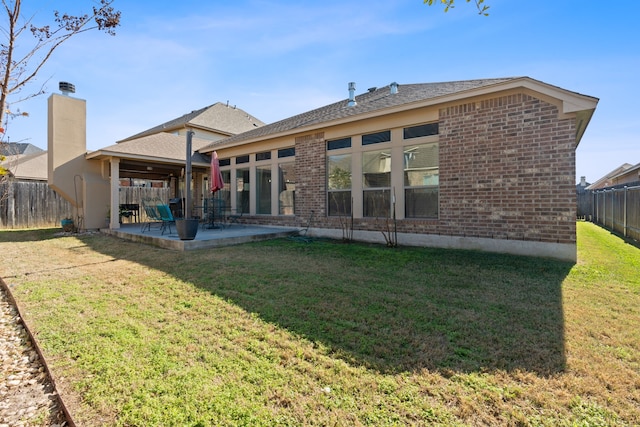 rear view of property with a patio area and a lawn