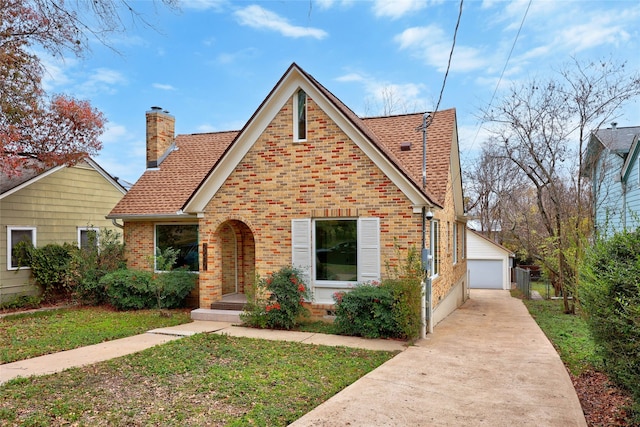 view of front of property with an outbuilding, a garage, and a front lawn