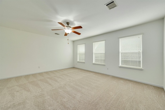 spare room featuring light colored carpet and ceiling fan