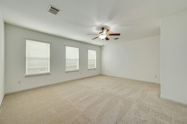 spare room featuring light carpet and ceiling fan