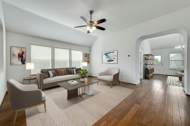 living room with dark wood-type flooring, ceiling fan with notable chandelier, and vaulted ceiling