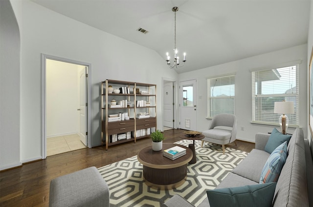 living room featuring vaulted ceiling, dark wood-type flooring, and a notable chandelier