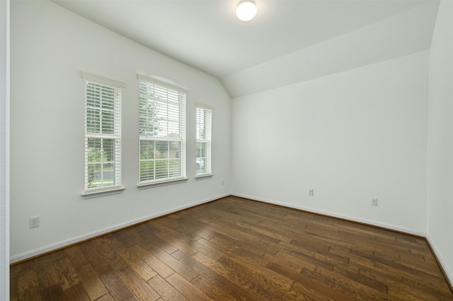 empty room featuring dark wood-type flooring and vaulted ceiling