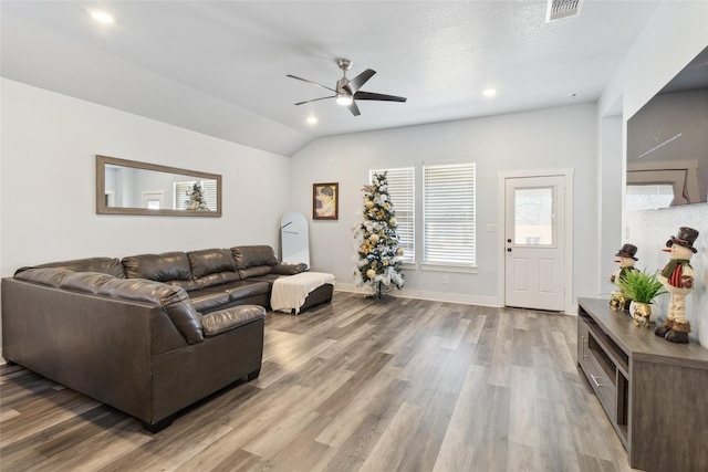 living room with ceiling fan, hardwood / wood-style flooring, and lofted ceiling