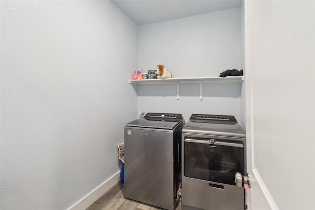 washroom with light hardwood / wood-style floors and washer and dryer