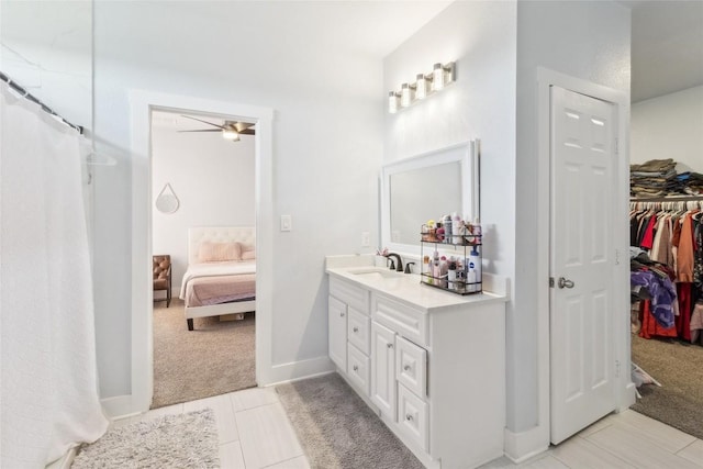 111 Lavender Cv, Dale, TX 78616 - ensuite bathroom with vanity, ceiling fan, a shower with curtain, a walk in closet, and tile patterned flooring